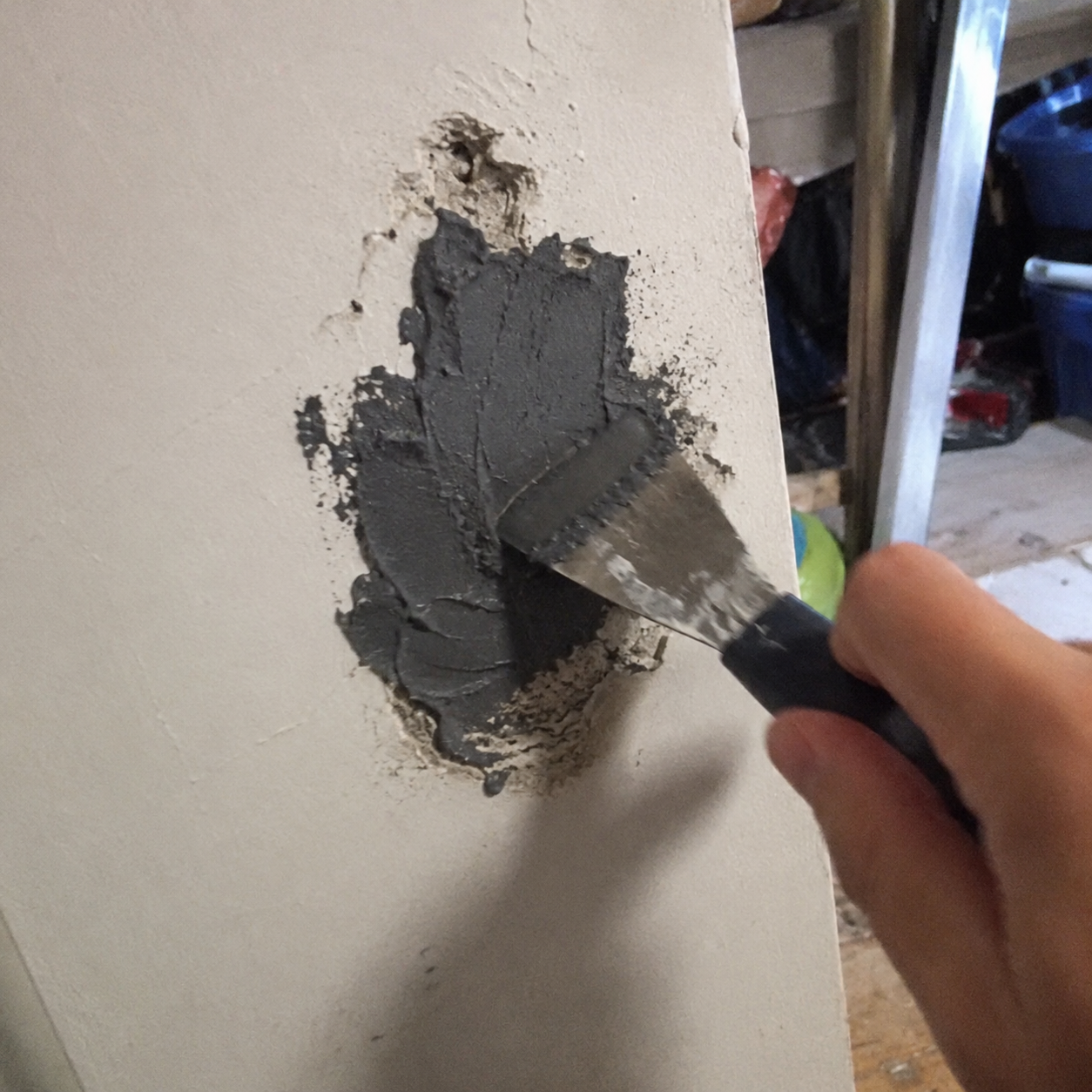 Customer filling and smoothing wall damage