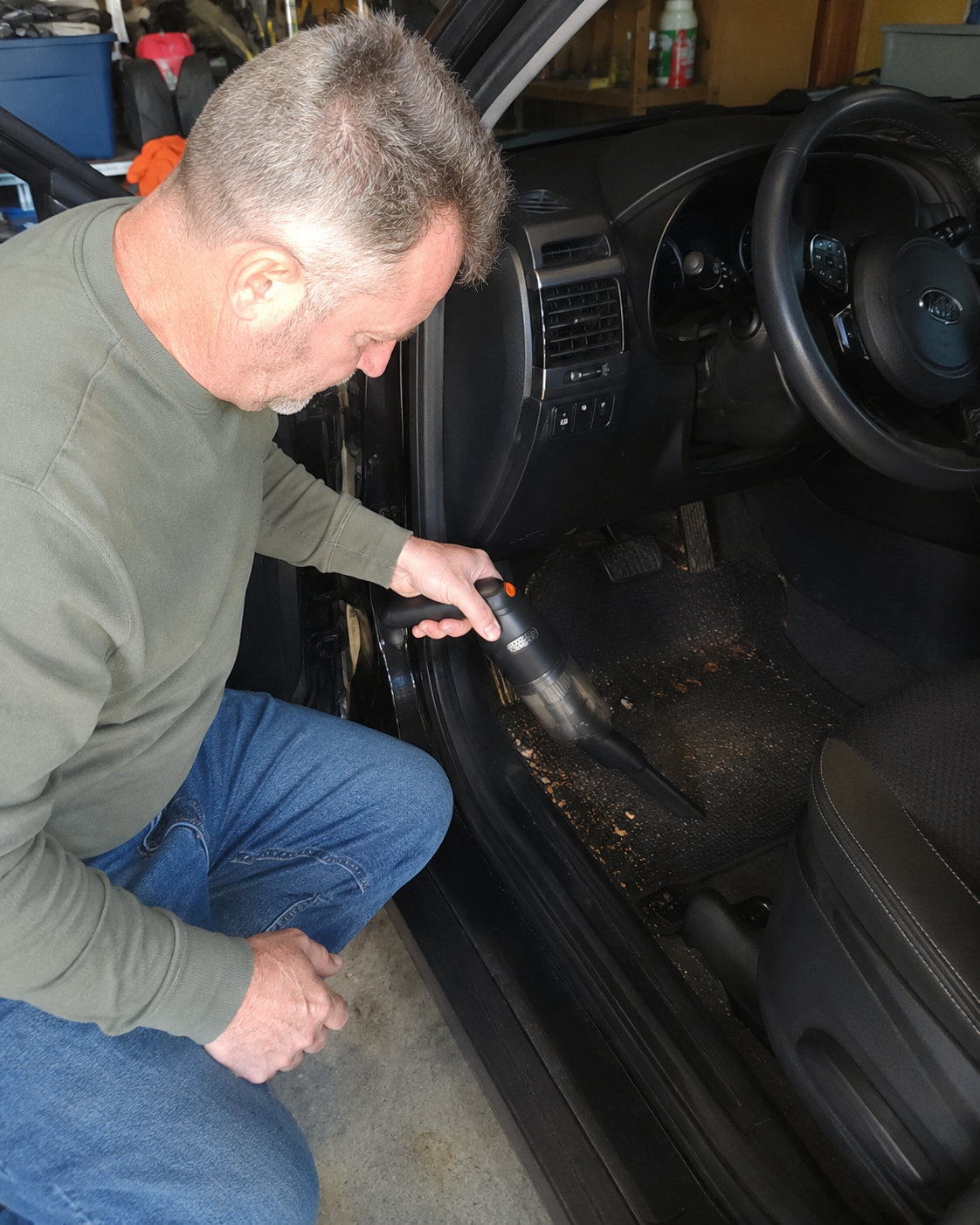 Customer vacuuming crumbs and debris from a car interior