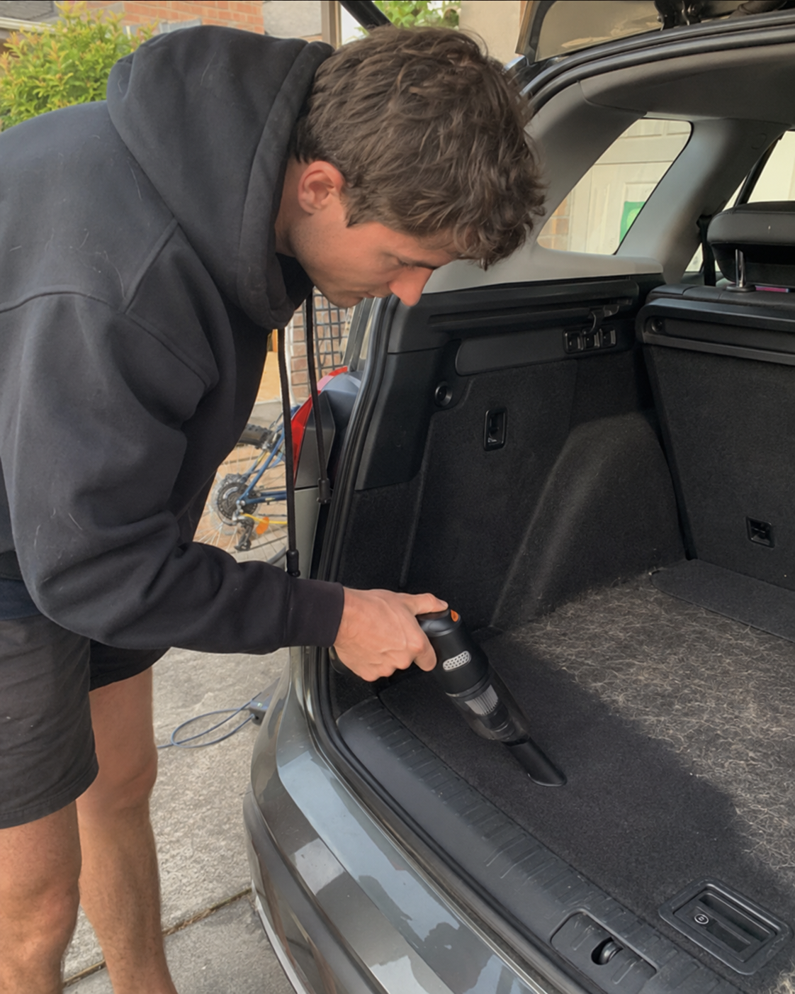 Customer cleaning debris from a vehicle interior