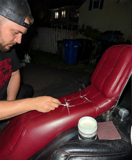 Customer repairing a worn red leather car seat